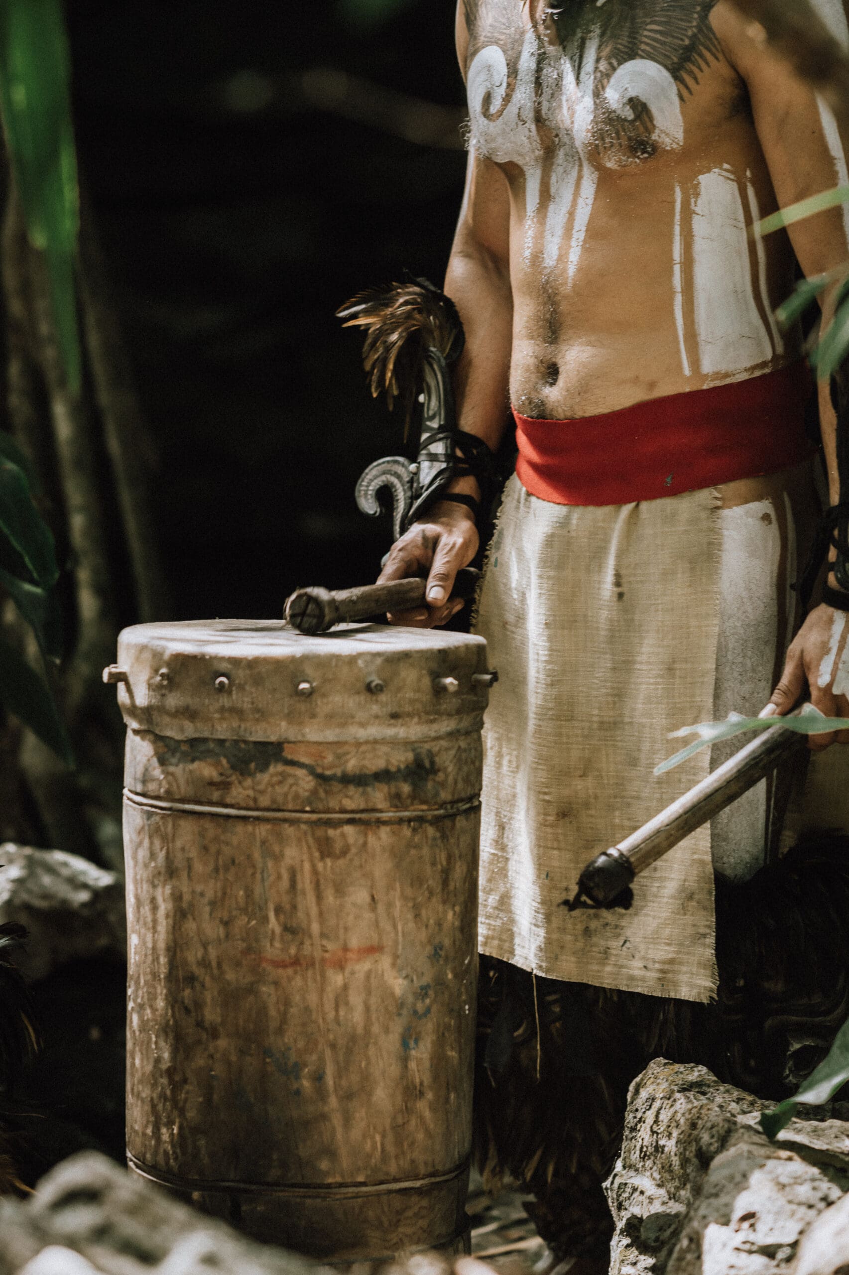Native Mayan musician hits the drum in a moment of celebration during a Mayan elopement ceremony in Tulum, Mexico.
