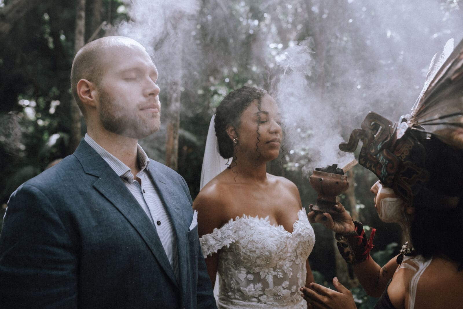 Husband and wife are cleansed with copal smoke by a Mayan medicine woman during their cenote elopement in Tulum.