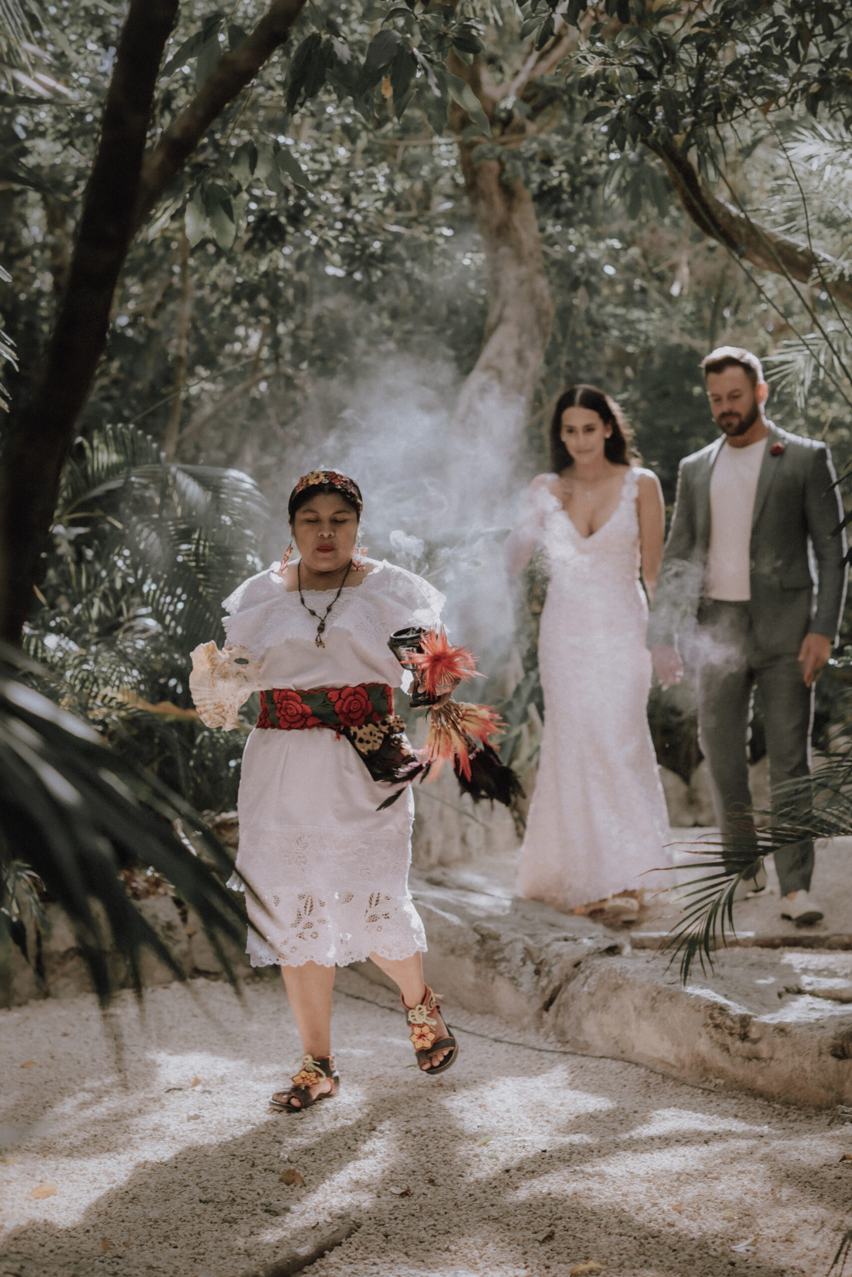 Couple is cleansed with copal during a Mayan elopement ceremony at a cenote in Tulum.