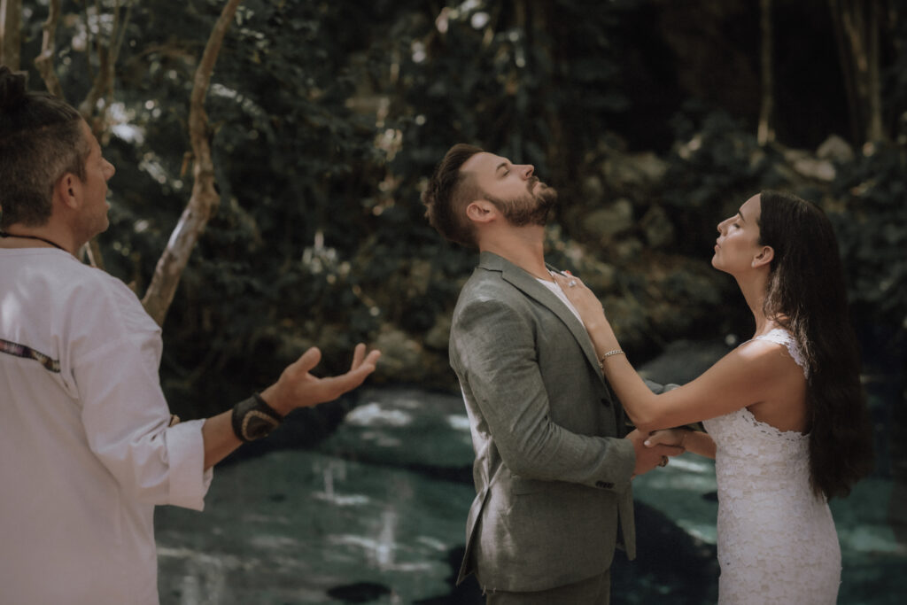 Bride and groom look up to the heavens during a mayan elopement ceremony in tulum.