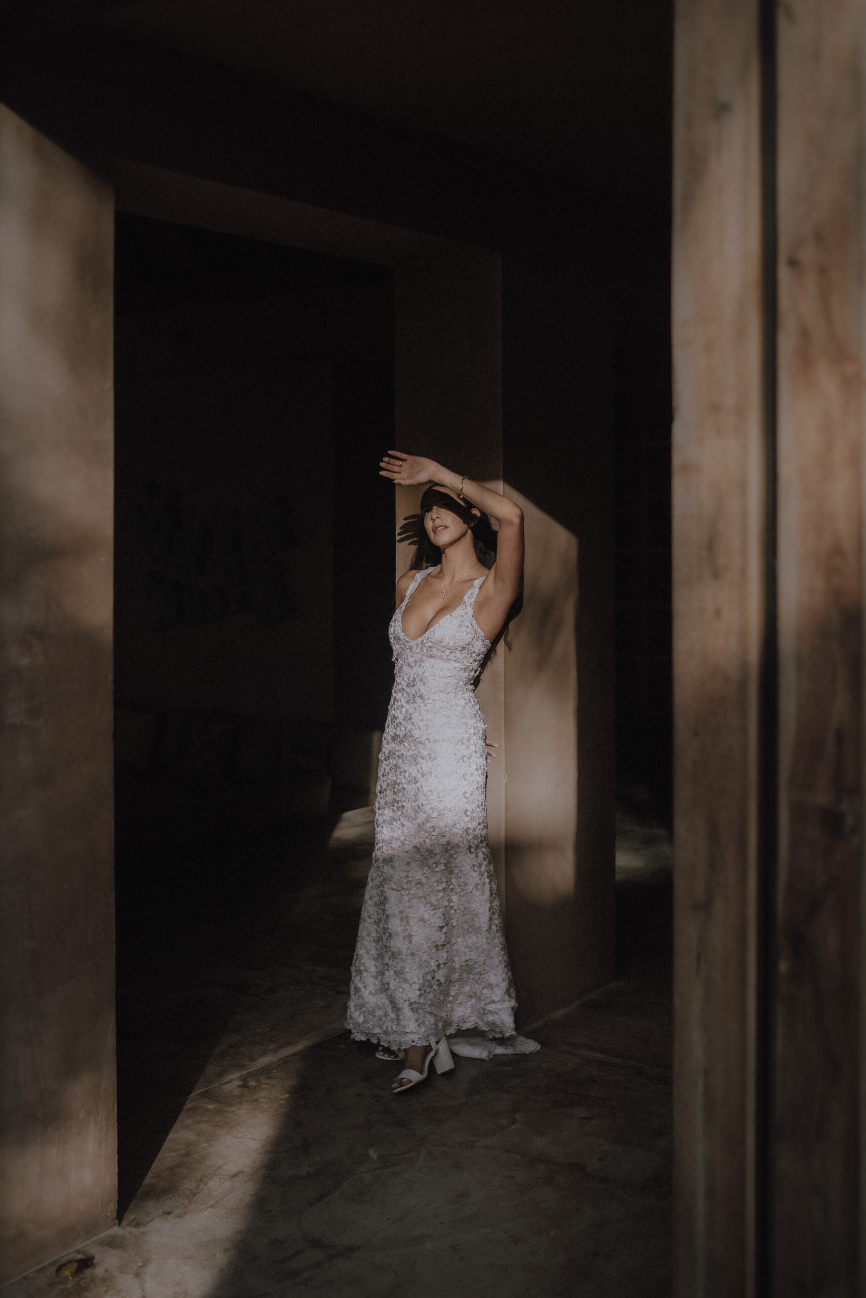 The sunrise enters Xela Tulum and the bride shades her eyes during an editorial elopement.