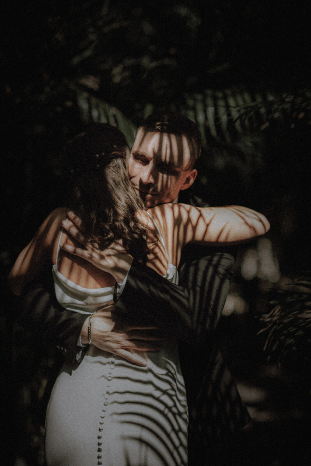 Palm shadows over a couple embracing in Tulum Mexico during their jungle elopement